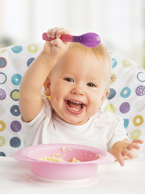 bébé qui mange en souriant